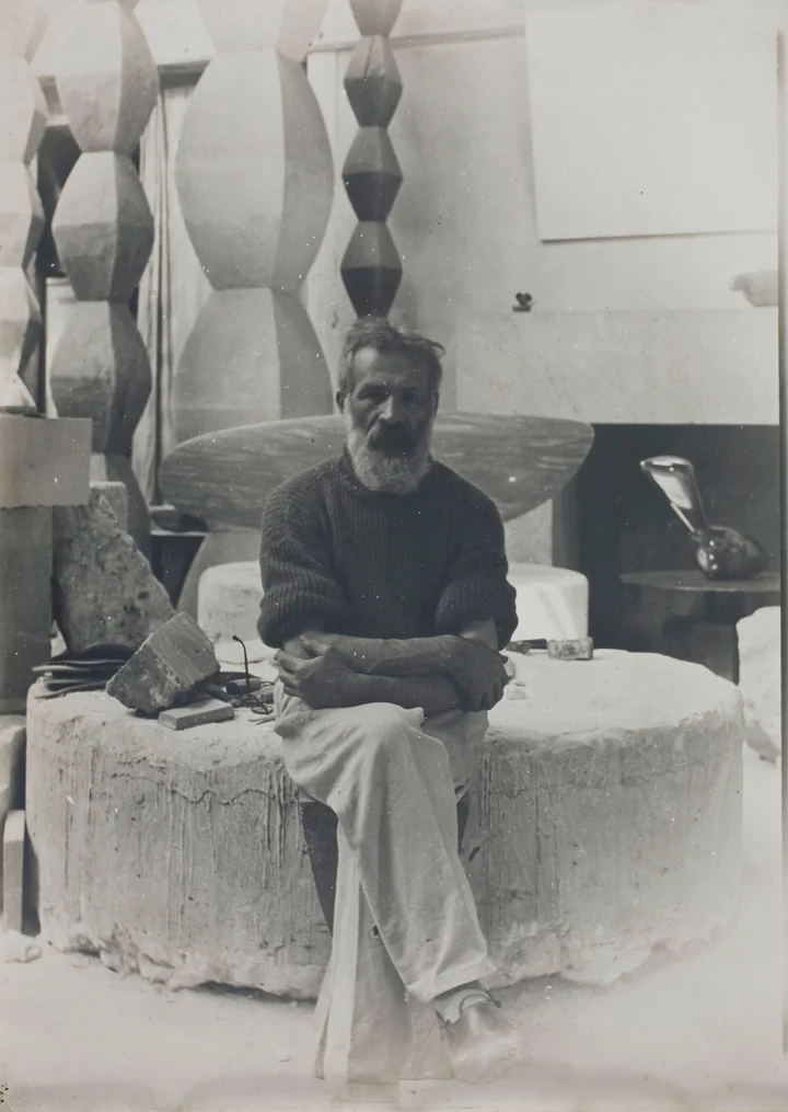 Constantin Brancusi — Brancusi in his studio, 11 Impasse Ronsin, with four Endless Columns in the background